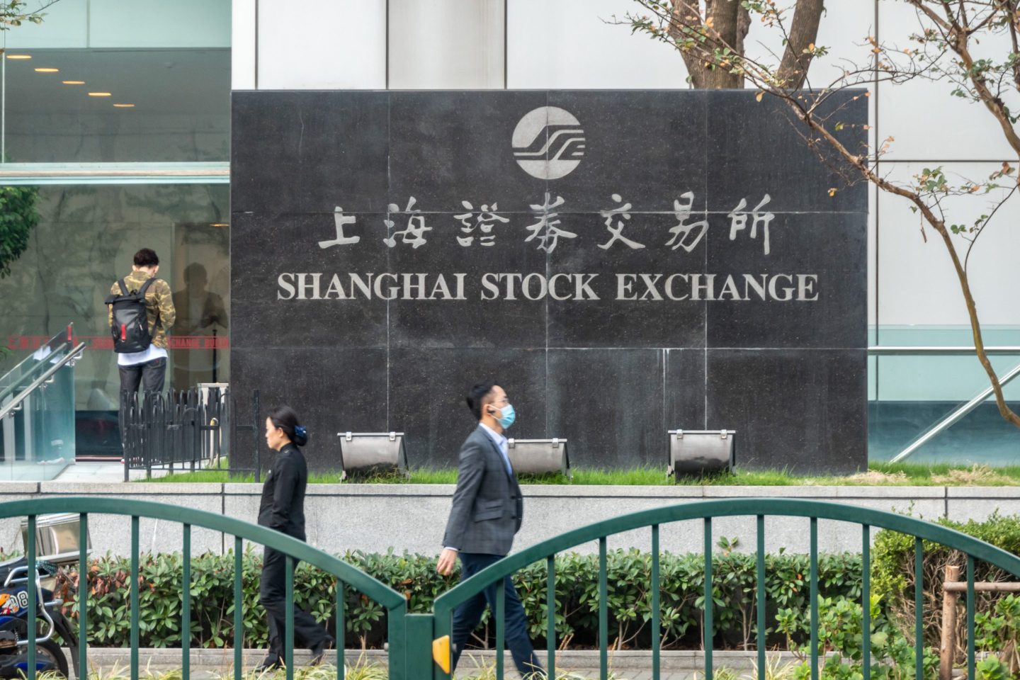 Photo of people walking by and standing outside the Shanghai Stock Exchange in Shanghai, China, on November 4, 2020.