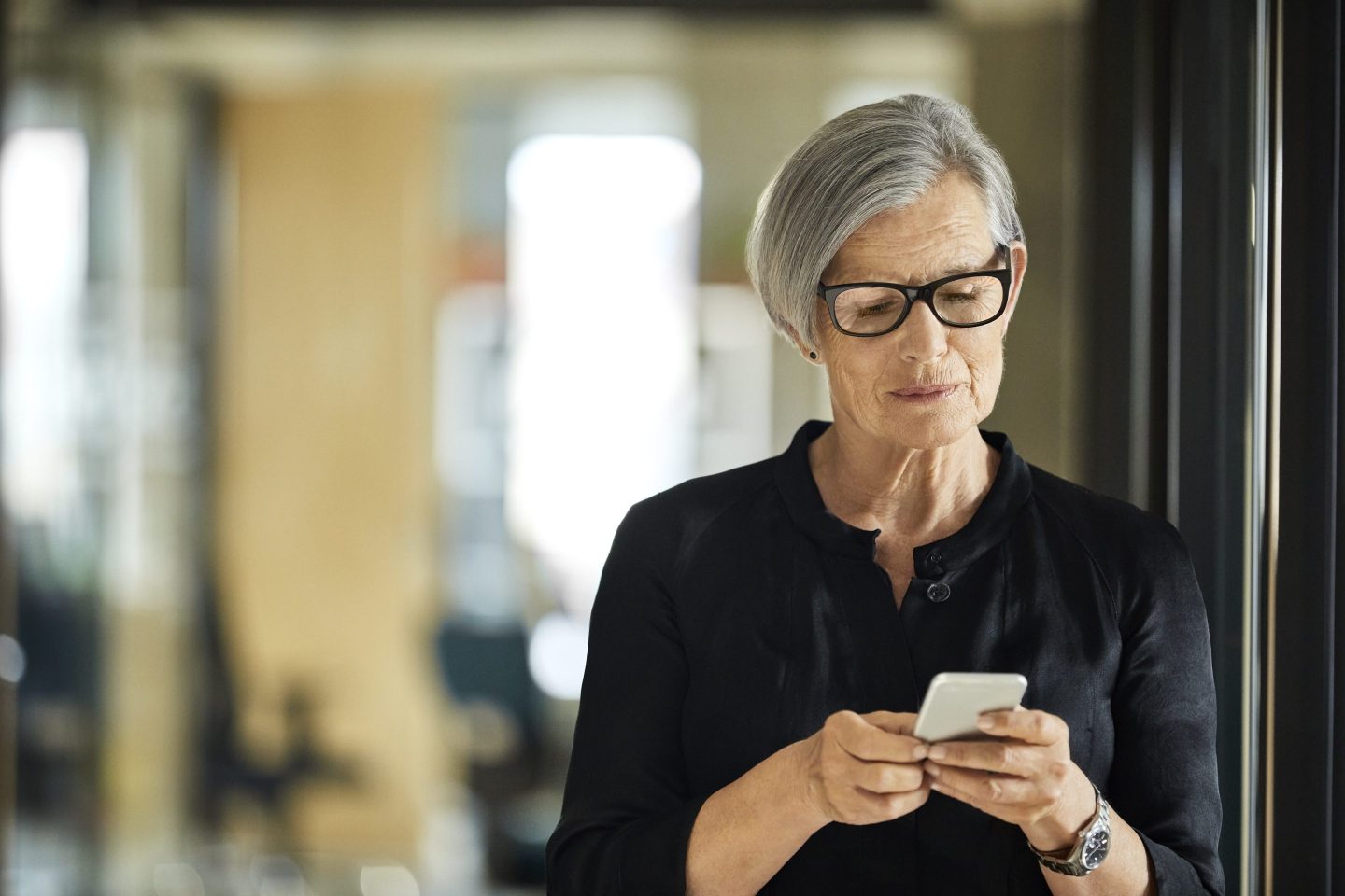 Senior Businesswoman Using Mobile Phone In Office