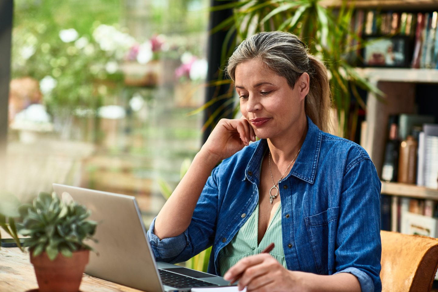 Woman sitting with laptop working from home