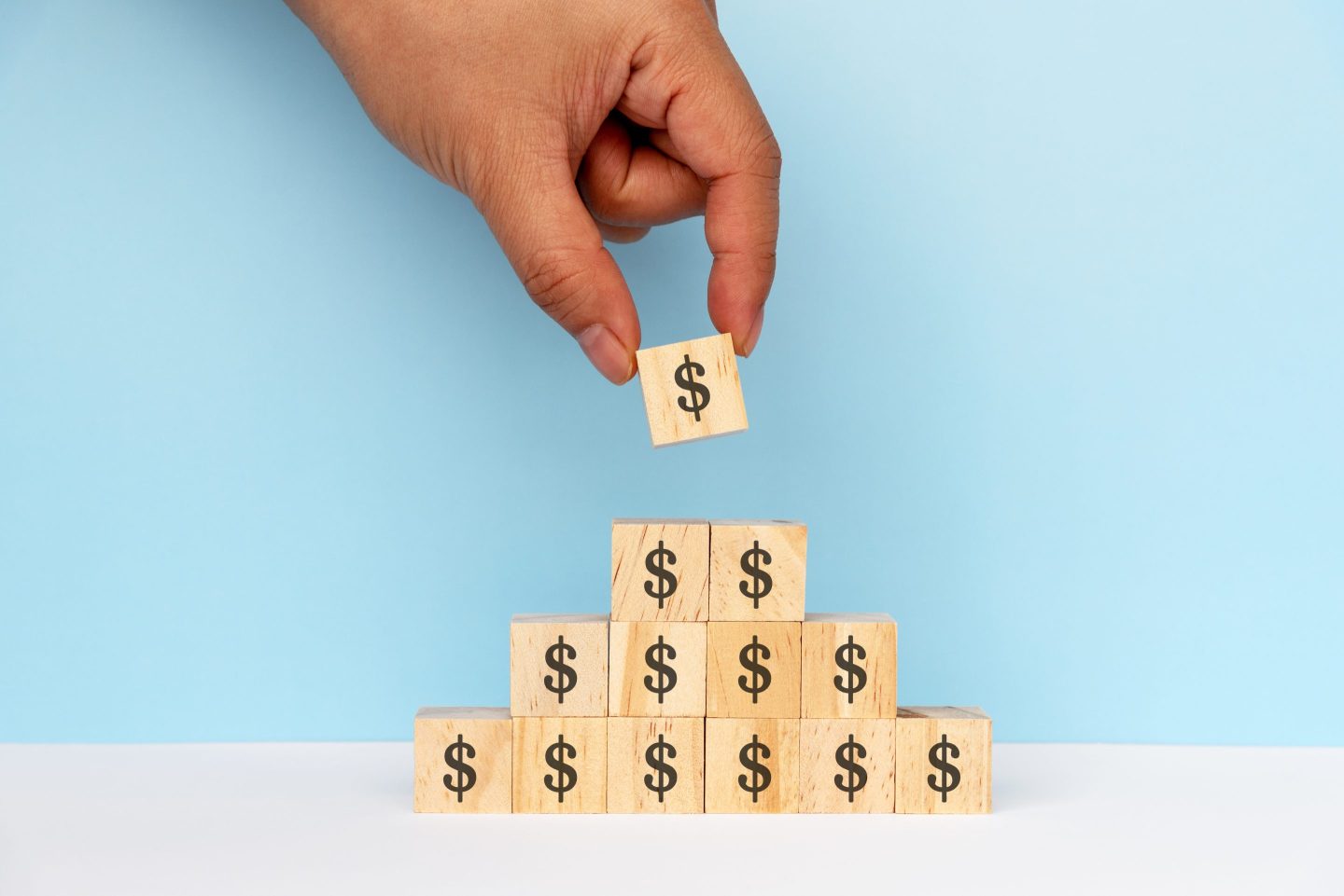 Hand stacks money blocks