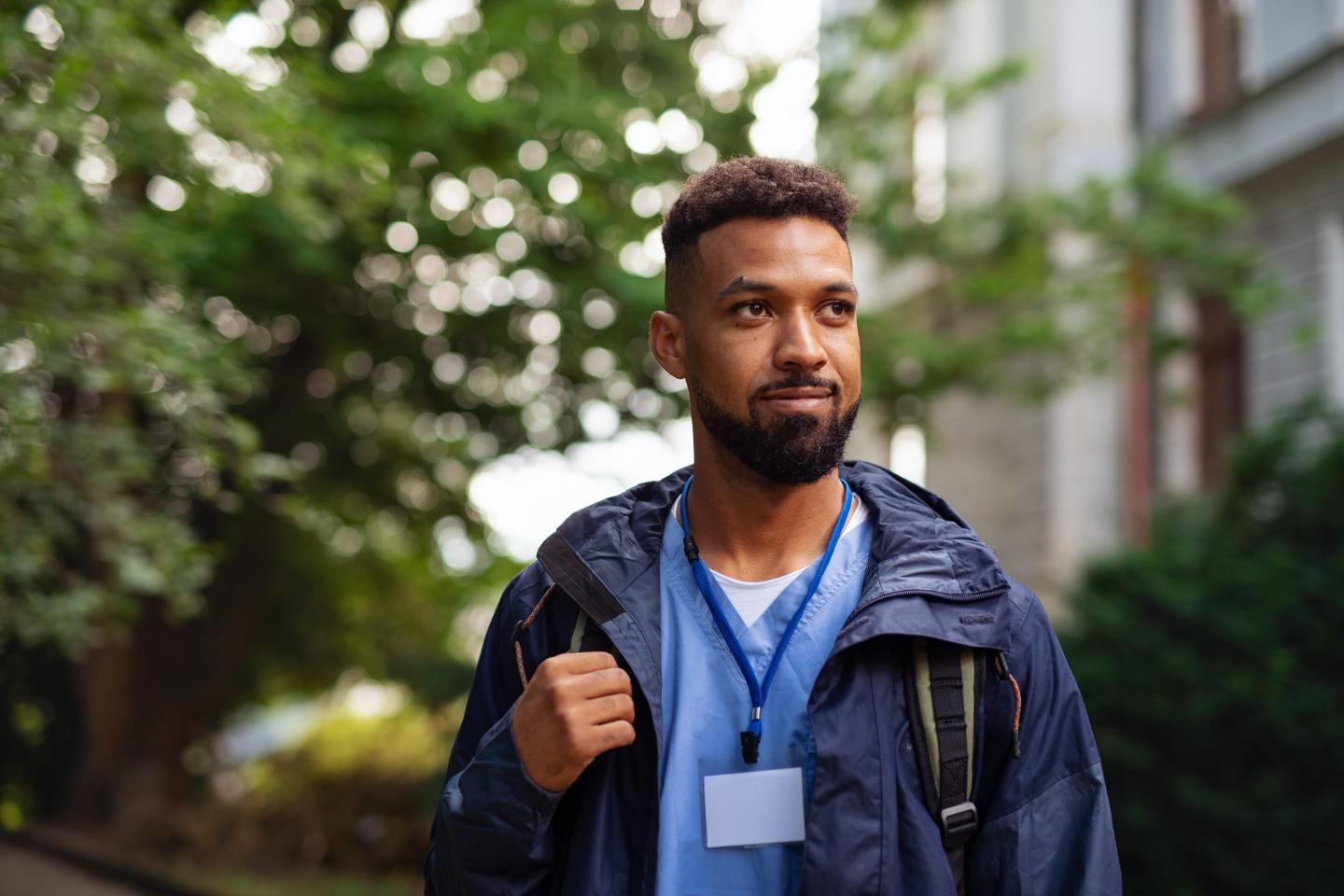 Man caregiver, male nurse or healthcare worker outdoors on the way to work.