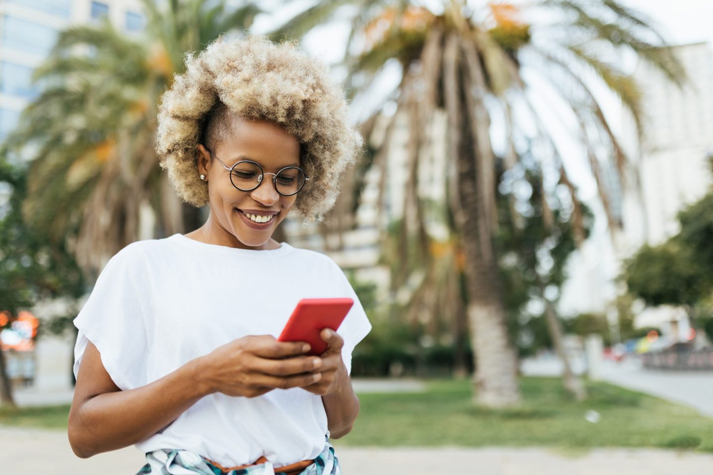 Woman looks at her phone while walking