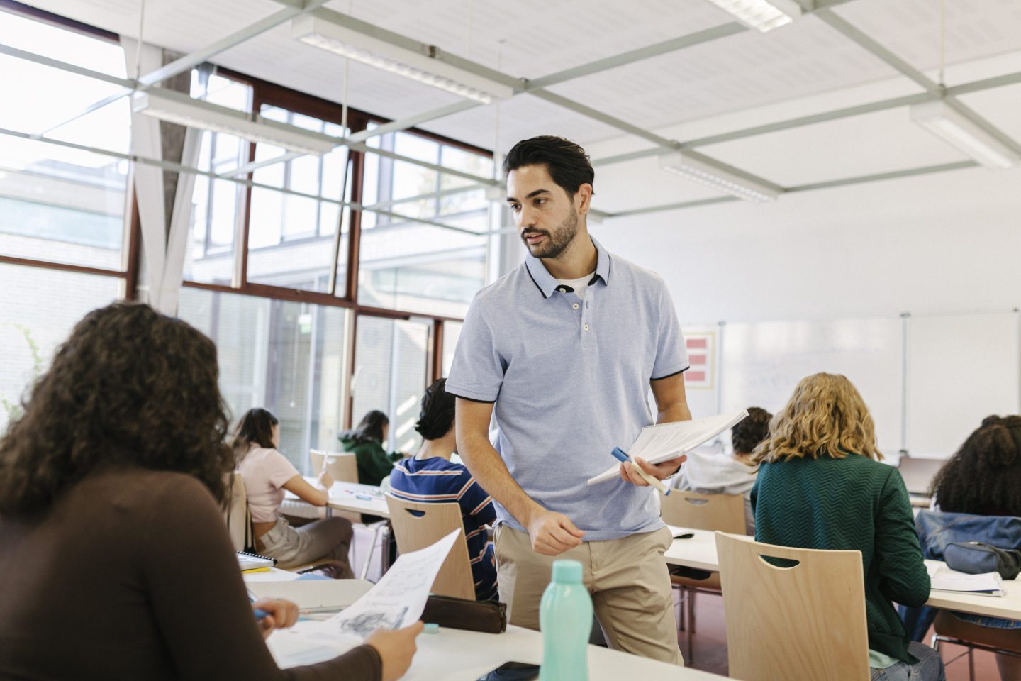 Teacher Handing Tests Out To Pupils