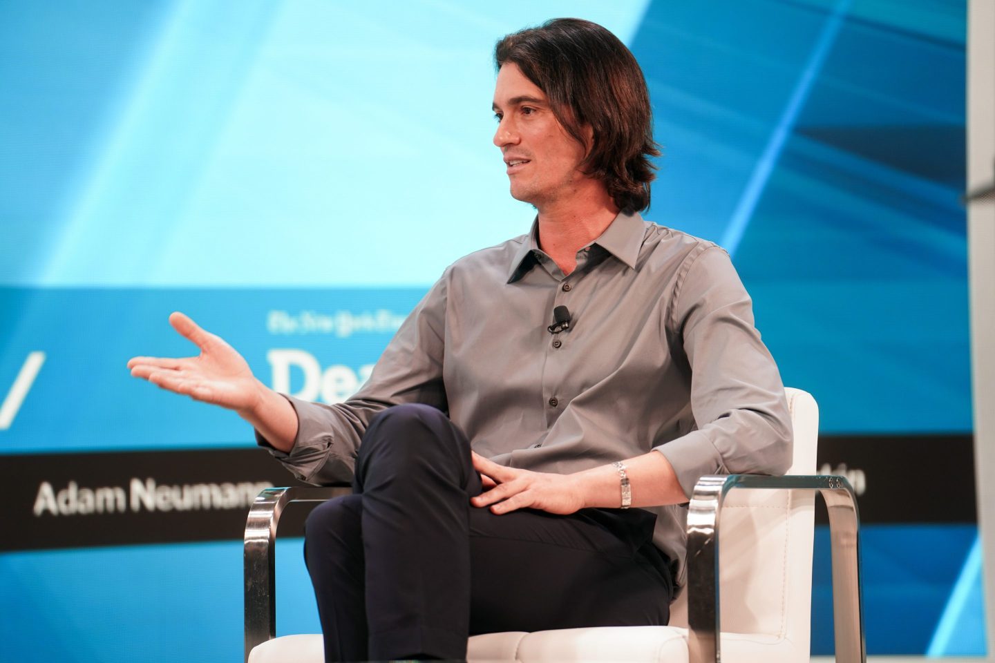 Adam Neumann speaks on stage at a conference.