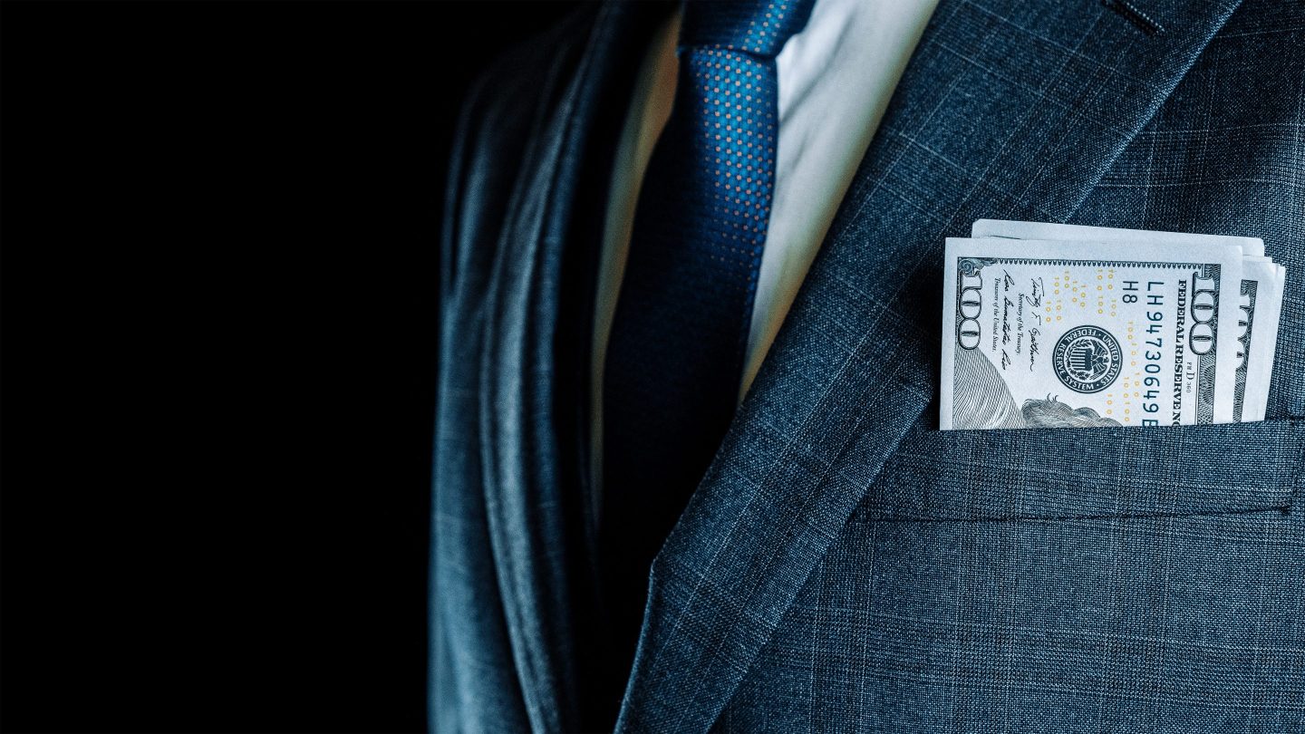 Hundred-dollar bills in men's suit pocket
