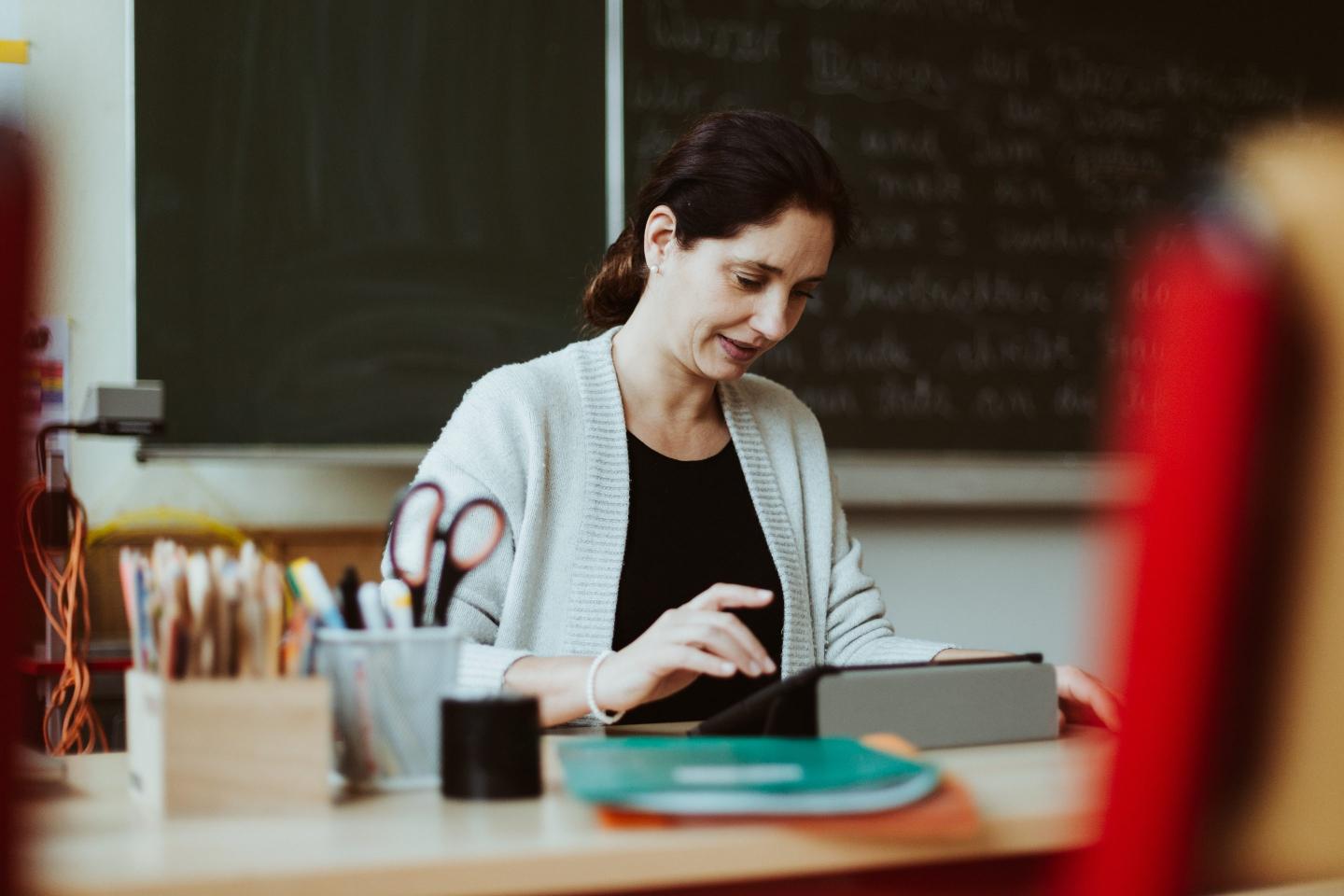 Teacher working on a tablet computer in a classroom