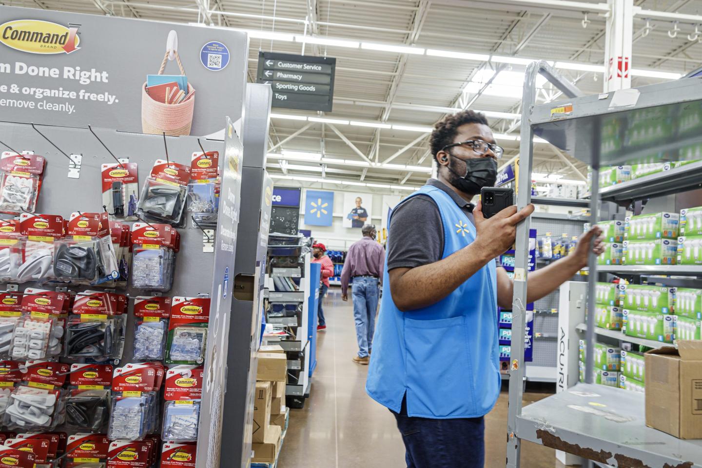 North Miami Beach, Florida, Walmart, Worker stocking shelves near 3M command display.