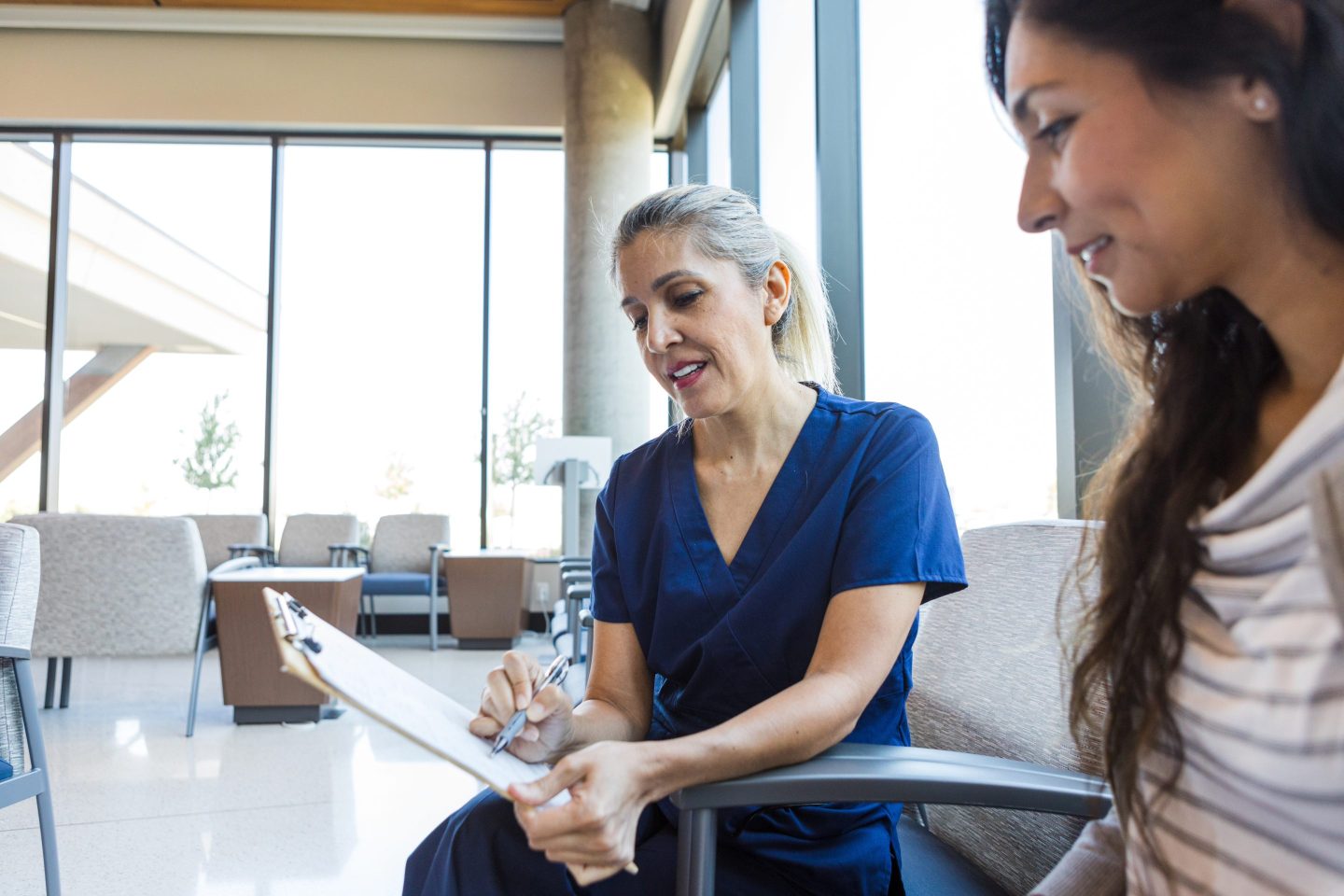 A nurse talks to a woman about health insurance forms