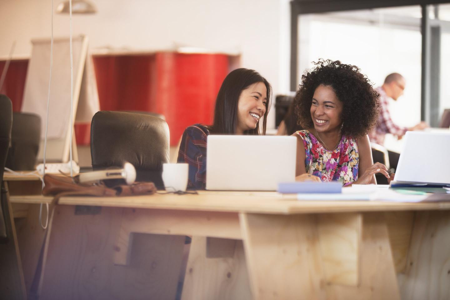 Two coworkers laugh together
