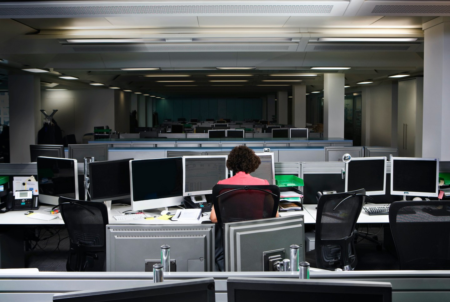 A business woman working late in an empty office.