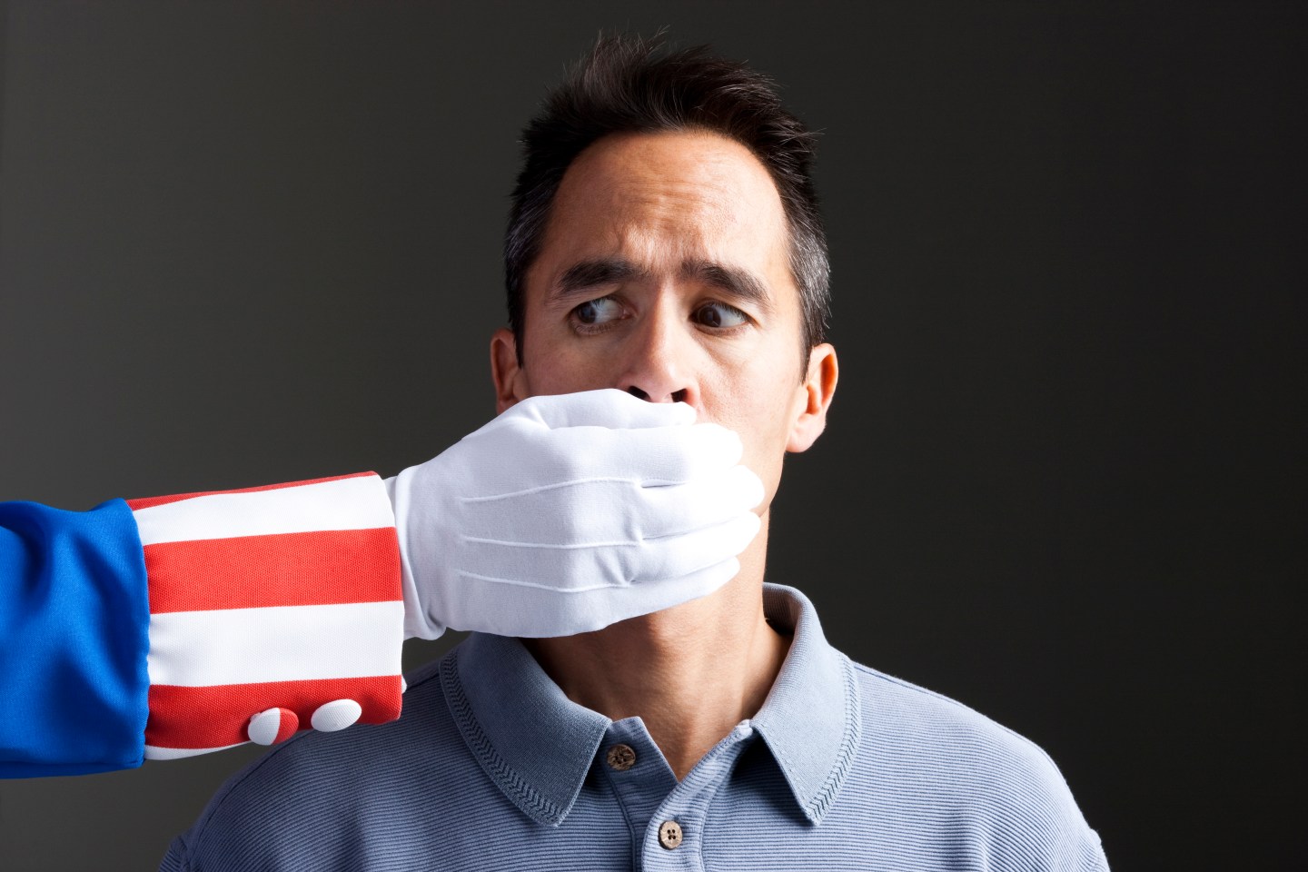 Human hand in Uncle Sam's costume shielding man's mouth