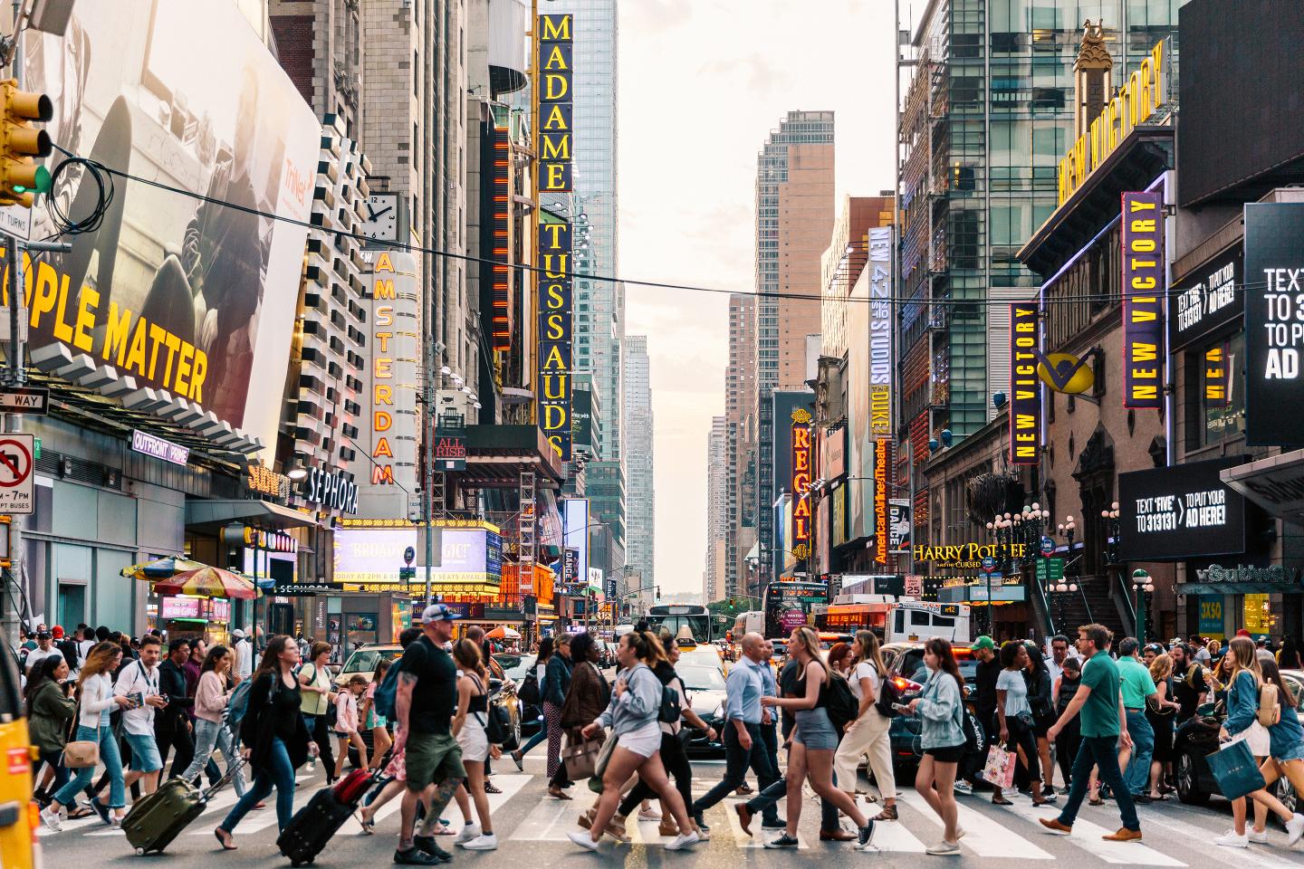 Crowds of people crossing street in New York City.