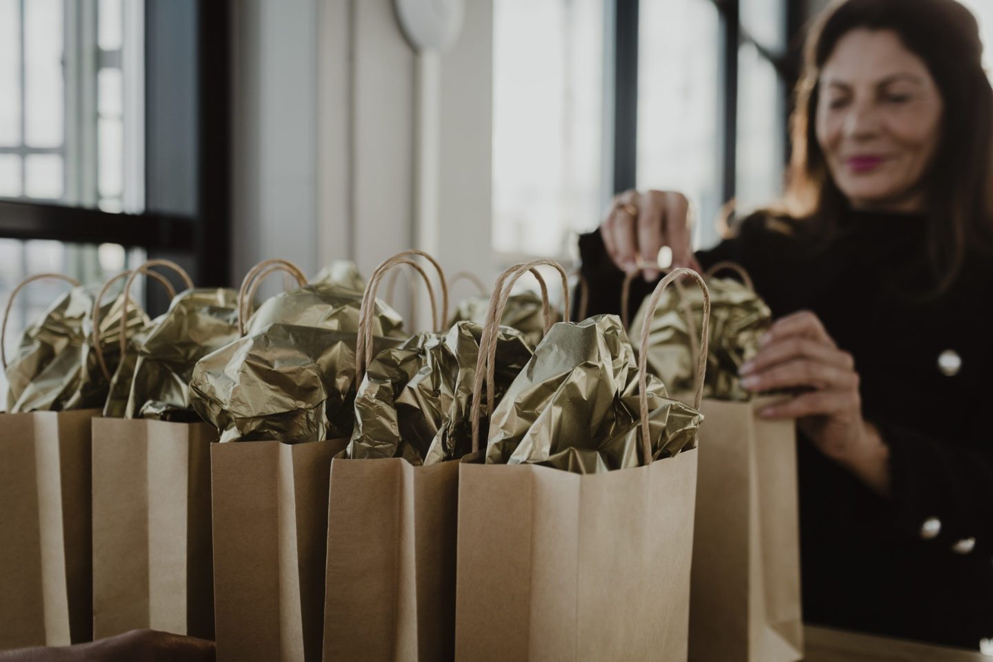 Woman CEO prepares gift bags in office.