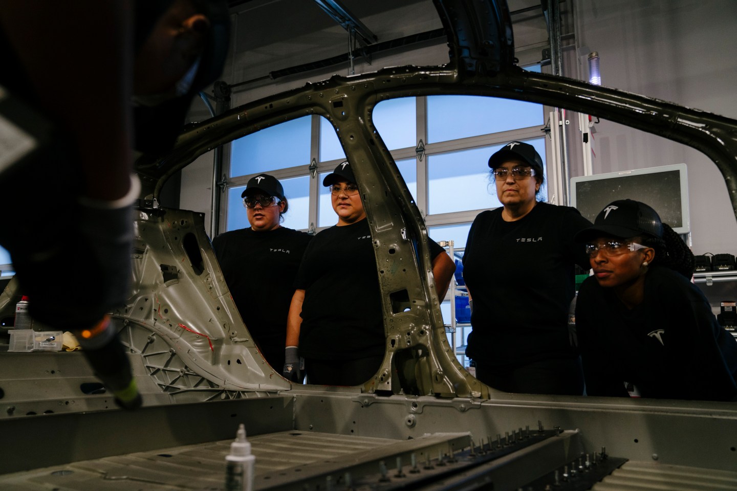 Tesla trainee employees watch a demonstration
