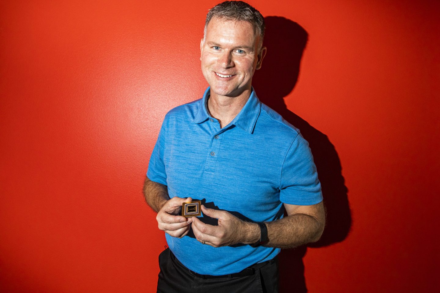 Photo of Tony Utley, chief operating officer of Quantinuum, holding a quantum computer chip.