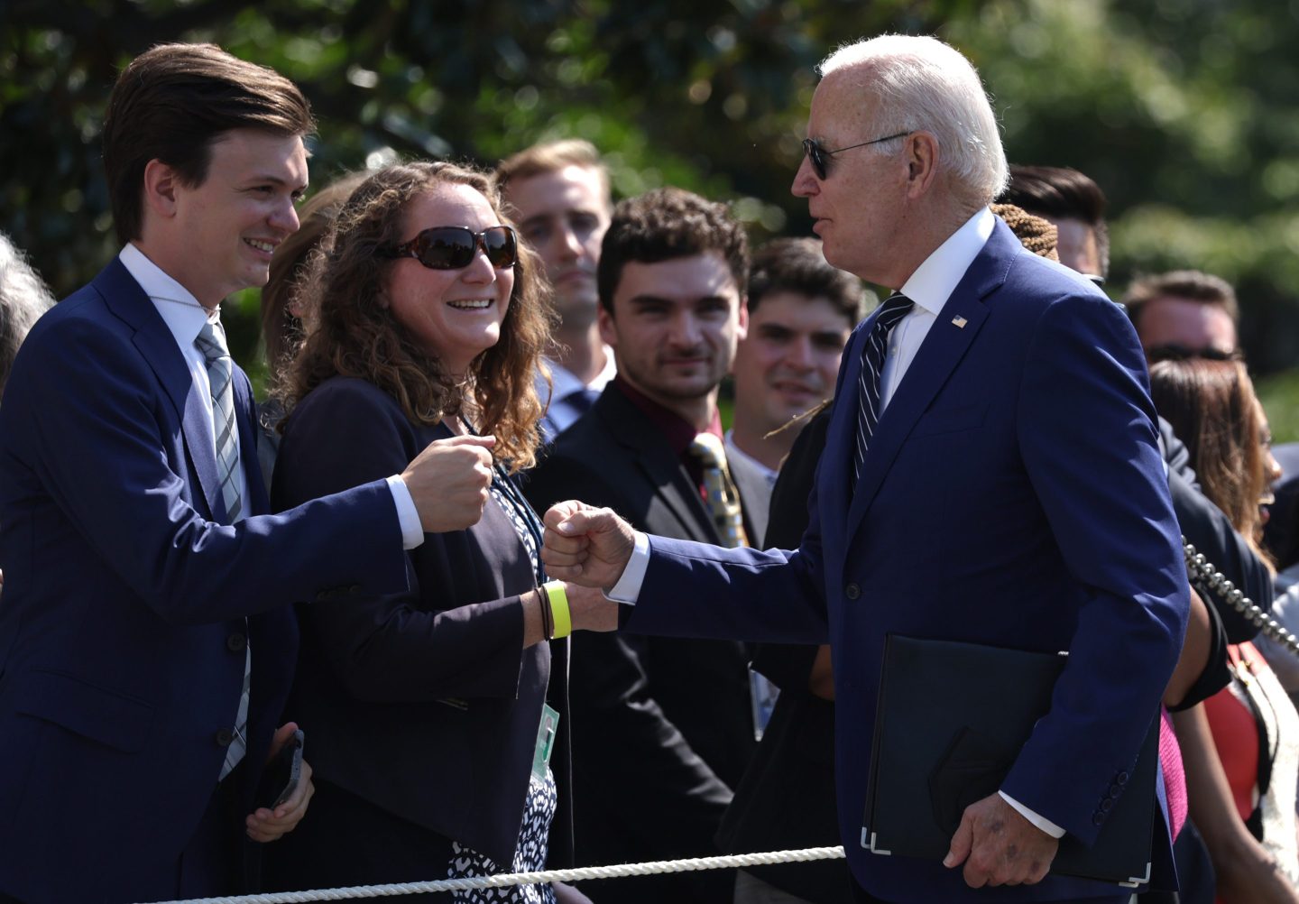 Biden fist bumps guests.
