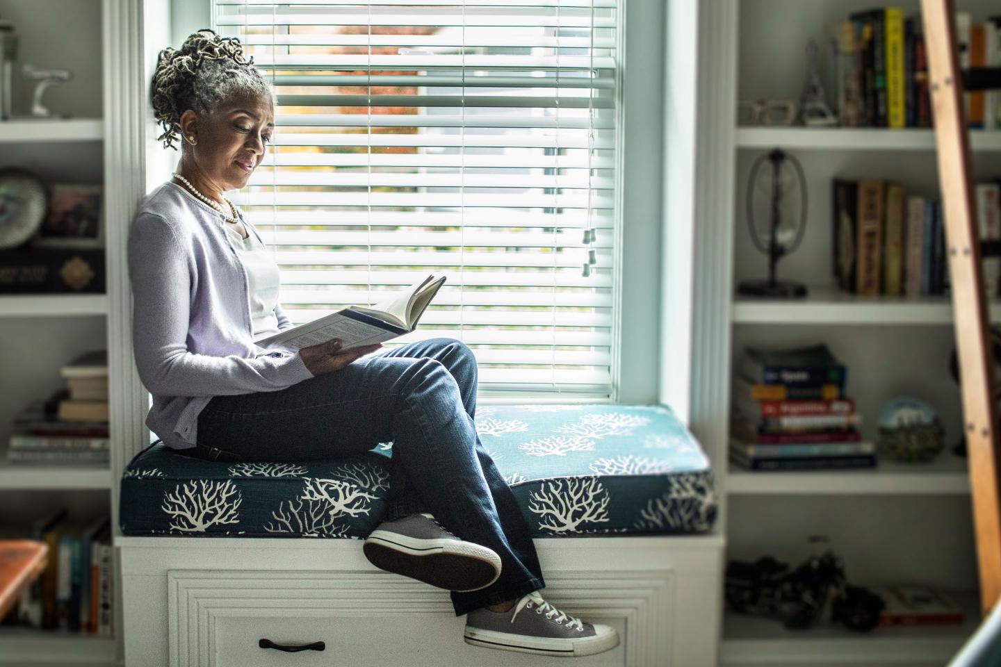 Senior woman reading in home library