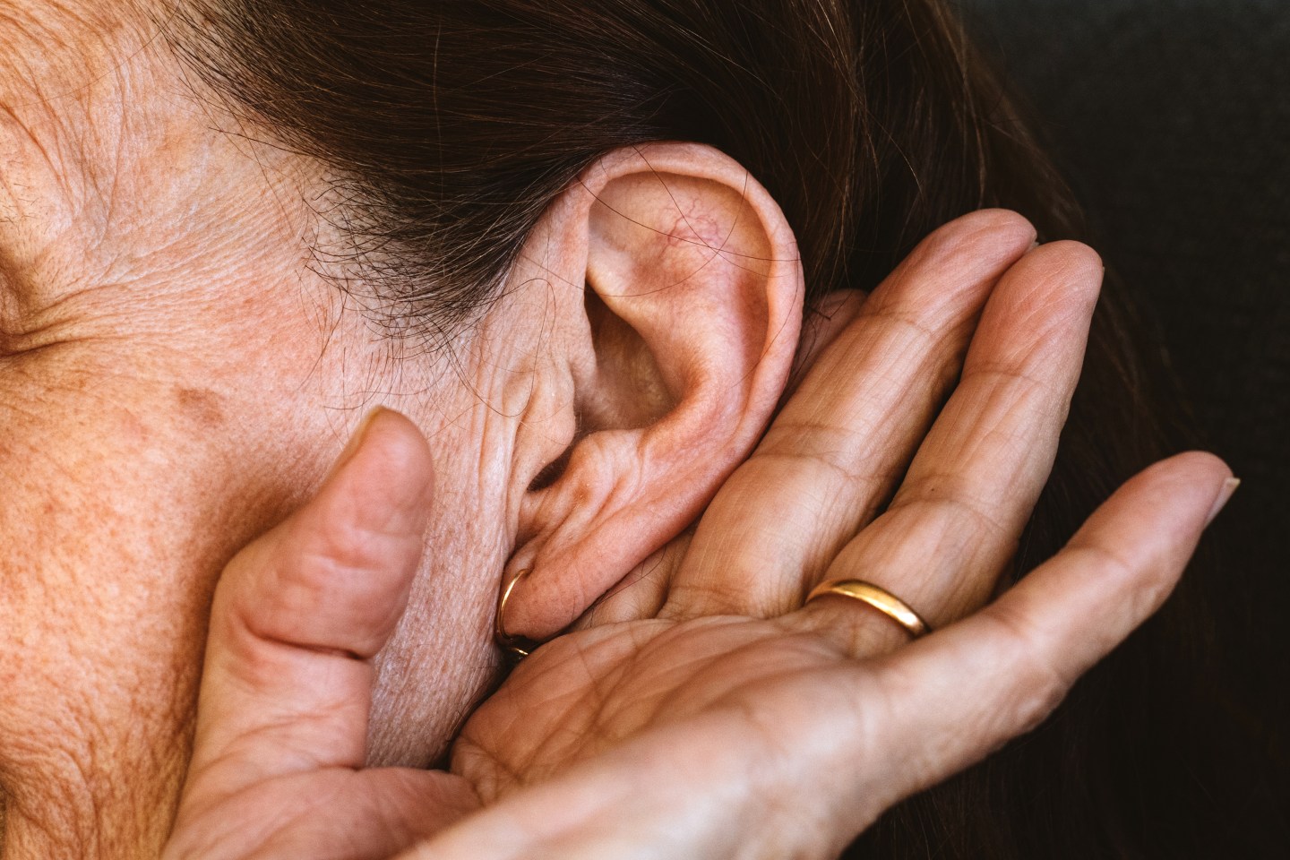 Woman holding ear to hear better