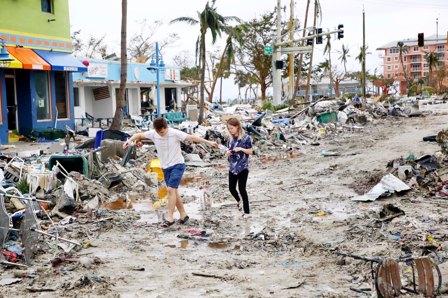 Jake Moses, 19, left, and Heather Jones, 18, of Fort Myers, explore a section of destroyed businesses at Fort Myers Beach, Fla., on Sep 29, 2022, following Hurricane Ian.