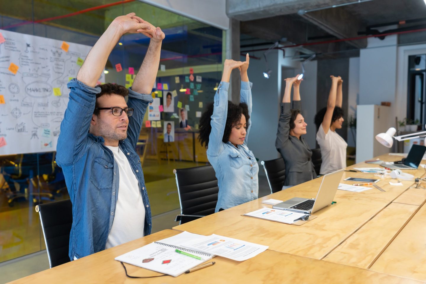 Employees stretching in meeting