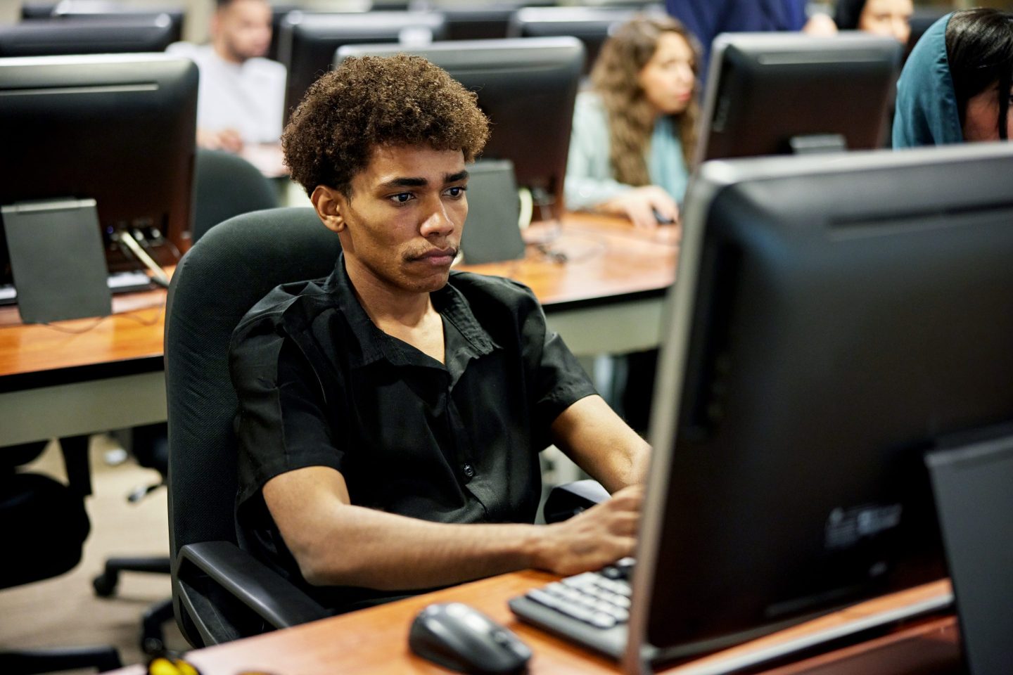 Student uses a computer while sitting in a computer lab.