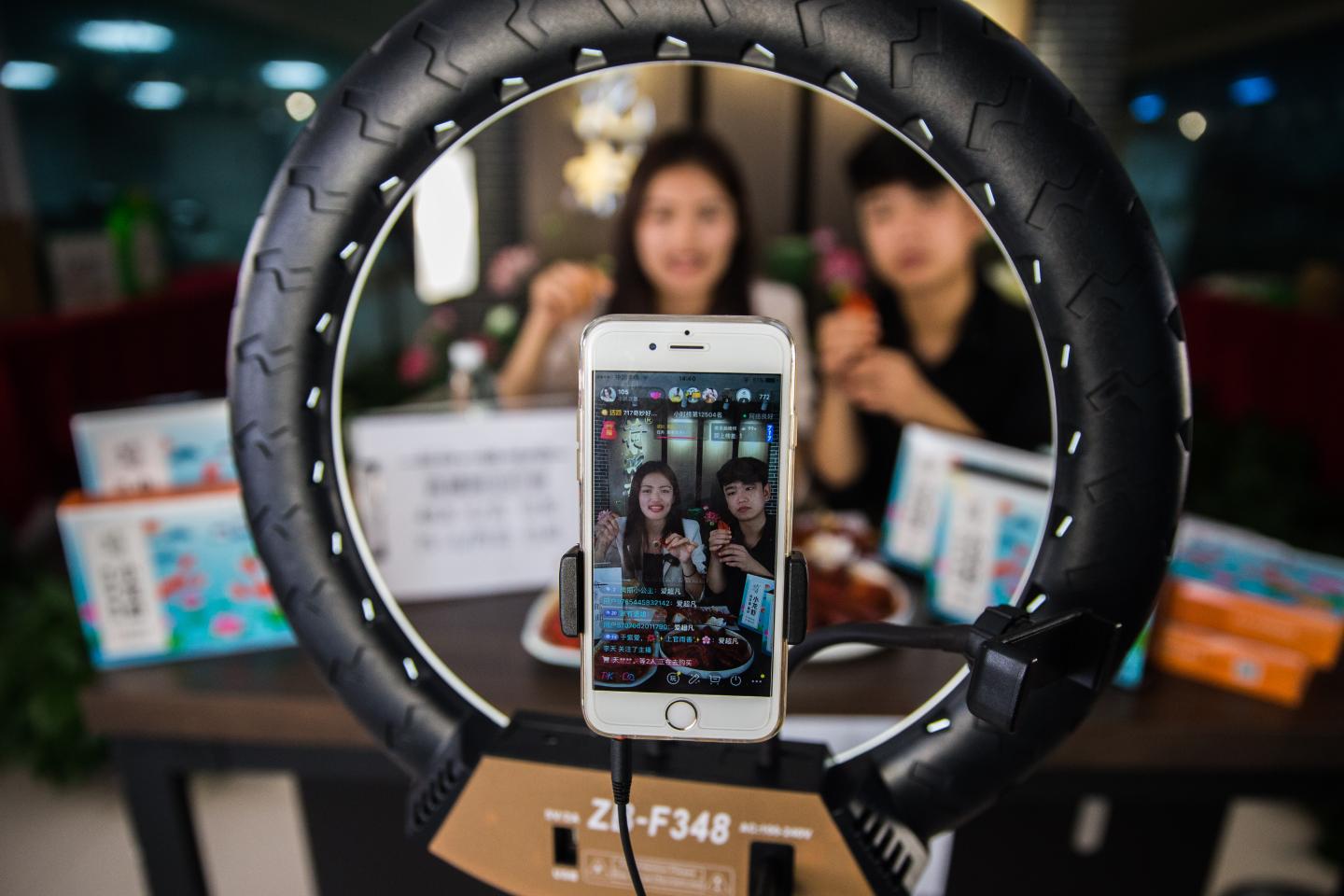 A smartphone is set up to film two people