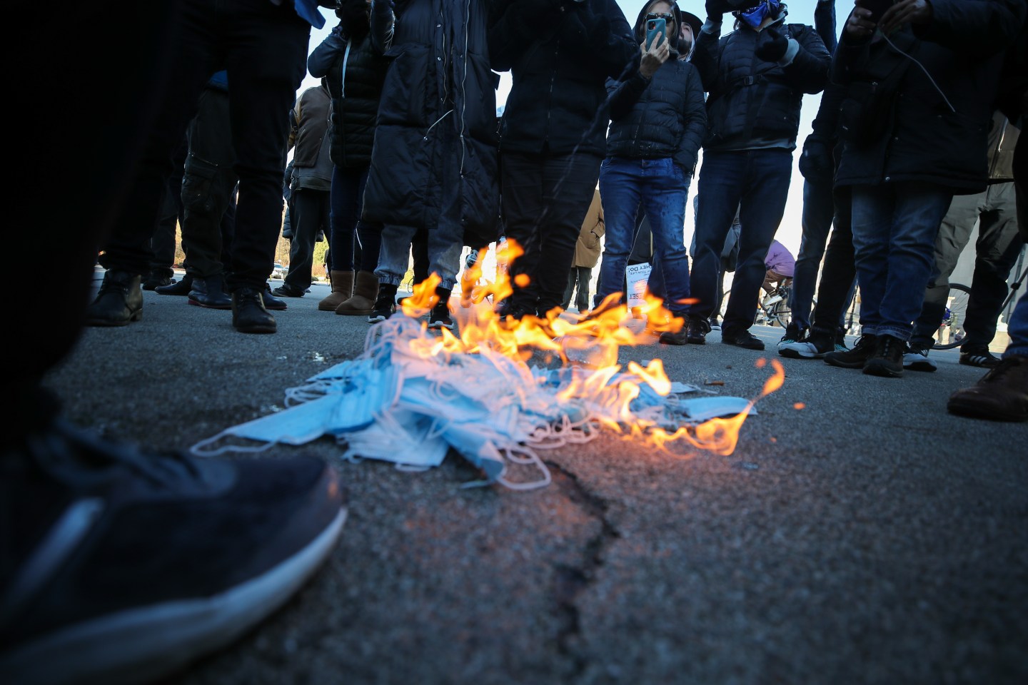 Anti-lockdown demonstrators burn face masks as they are gathered at the Grand Army Plaza to protest coronavirus restrictions in Brooklyn, New York, on Dec. 6, 2020.