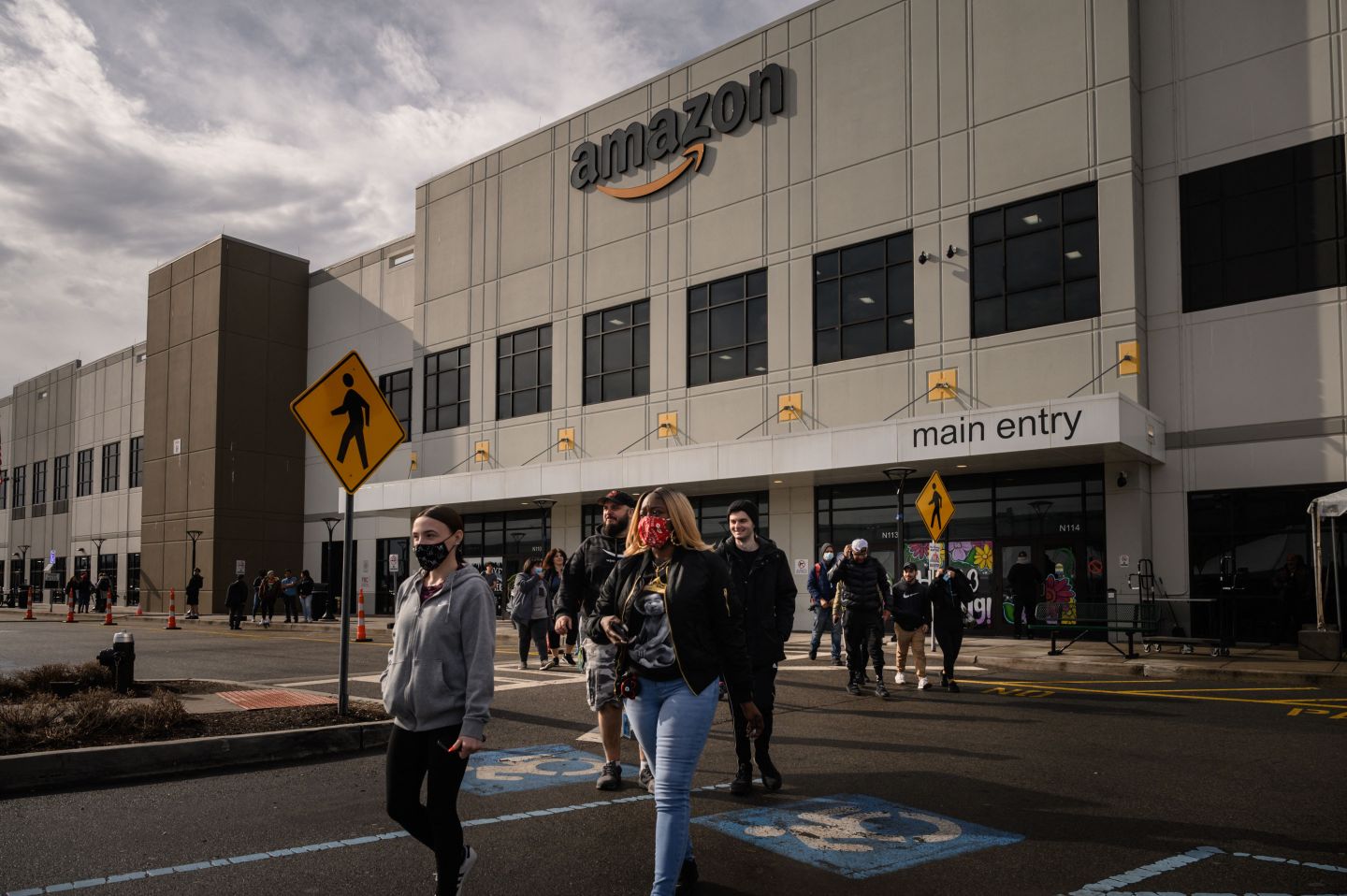 Workers walk to cast their votes over whether or not to unionize, outside an Amazon warehouse in Staten Island on March 25, 2022.