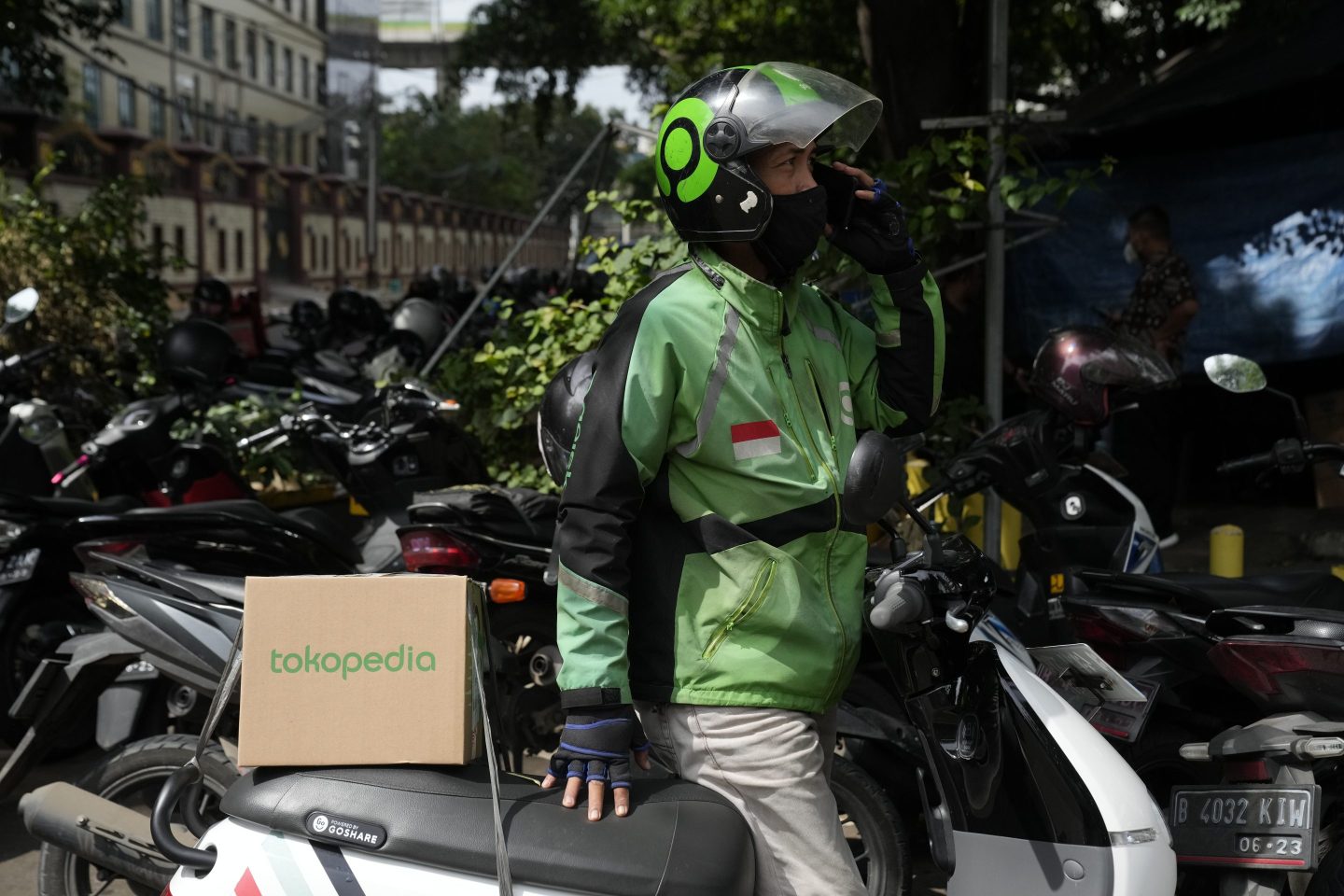 A GoJek driver carries a Tokopedia box on his motorcycle