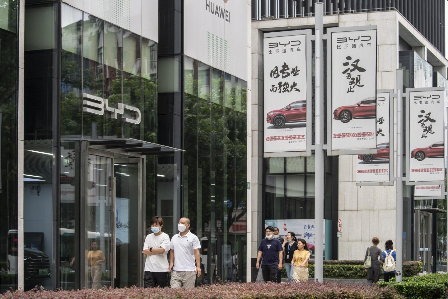 Consumers in Shanghai walk past a BYD showroom