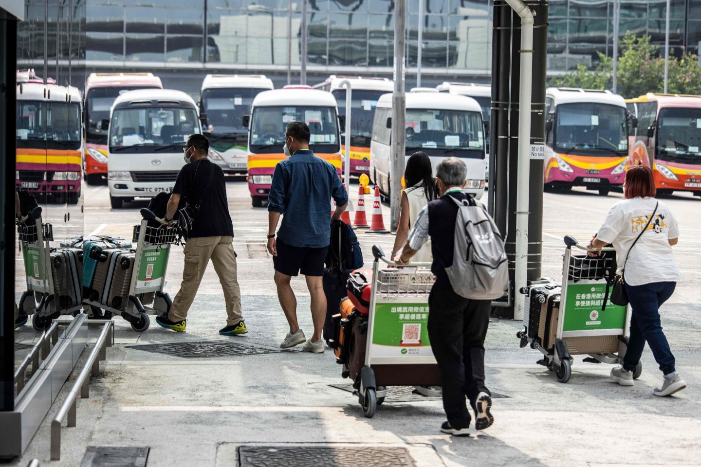 Arrivals in Hong Kong walk to a bus at Hong Kong's international airport