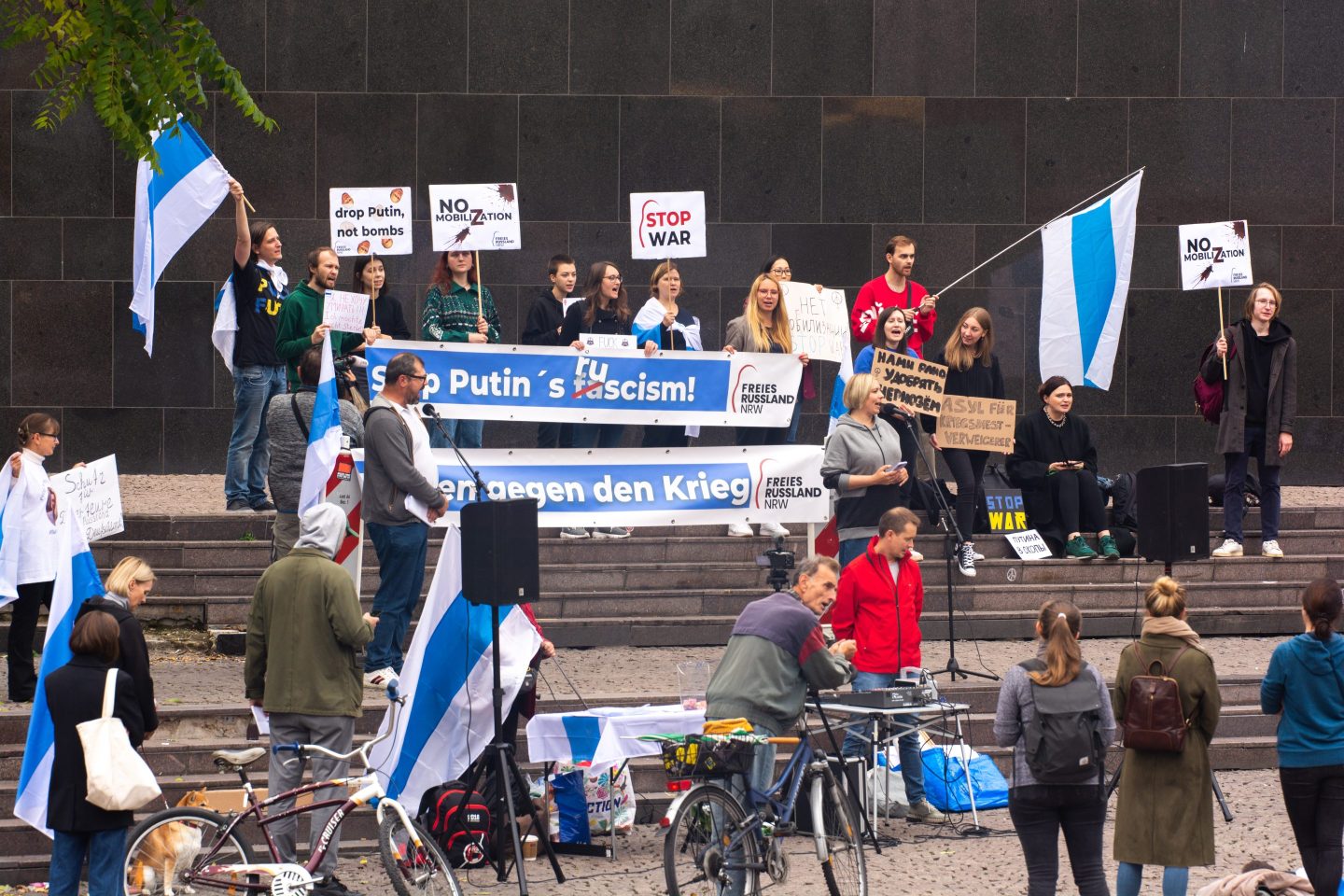 Protesters are seen holding up white blue white anti war flag protest against Moscow partial military mobilisation of Russian reservists in Duesseldorf, Germany on Sept. 24, 2022