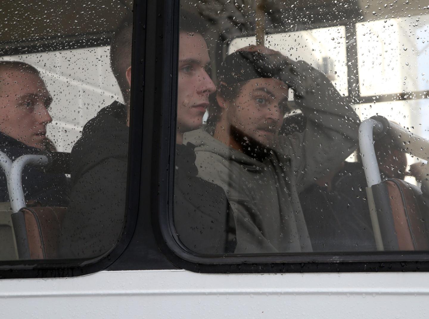 Russian men sit on the bus waiting for their departure to a military training centre.
