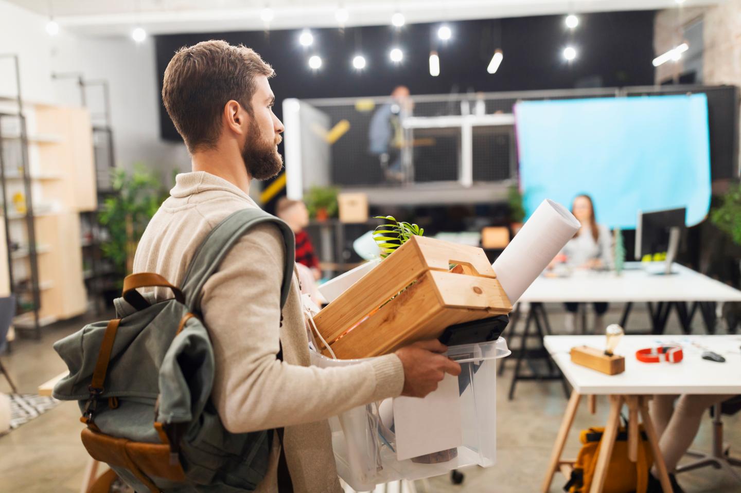 Millennial worker leaving the office with a box of his things