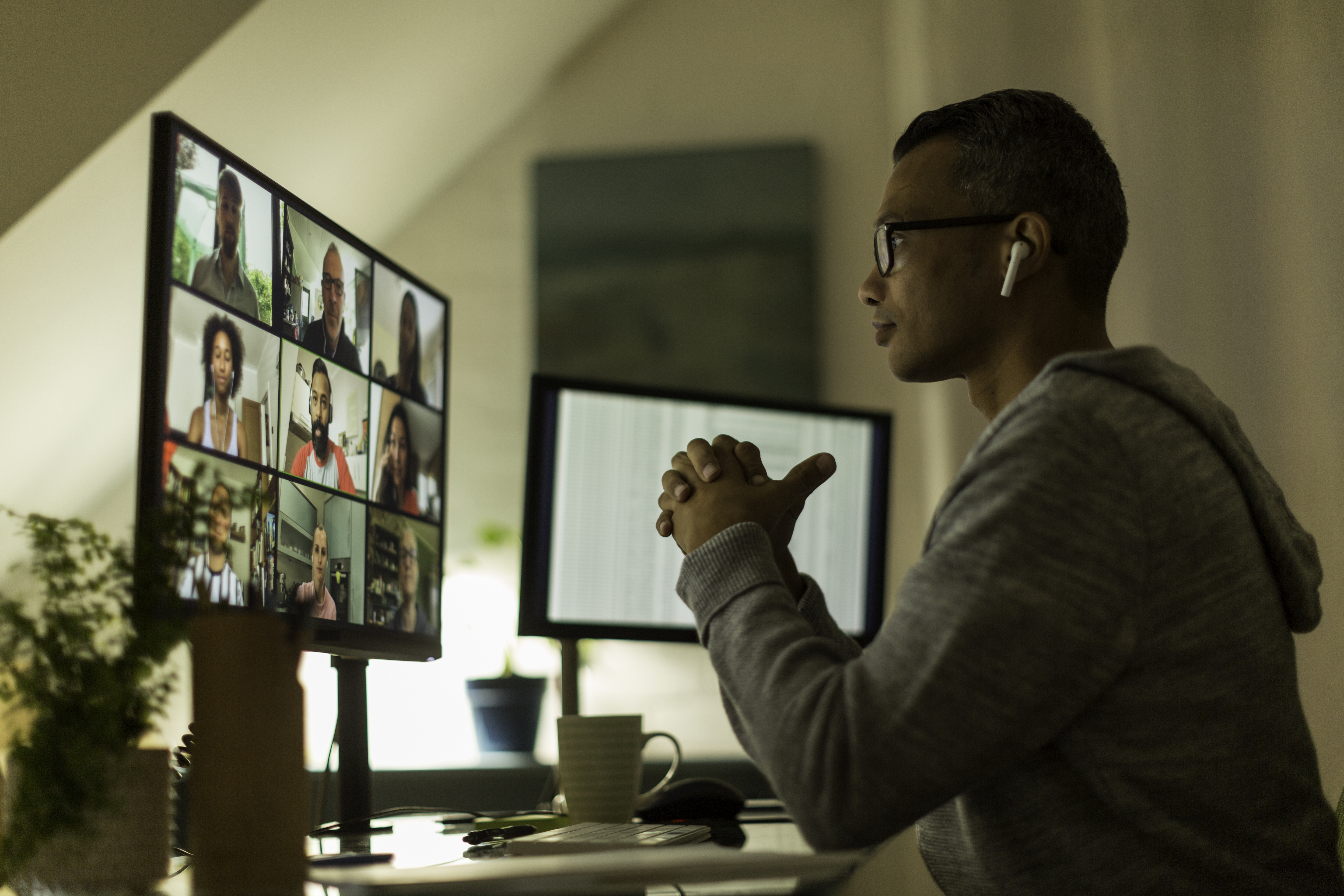 Man working from home speaks to colleagues on a video call