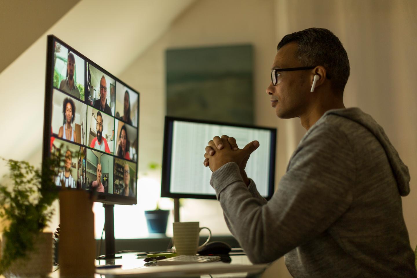Man working from home speaks to colleagues on a video call
