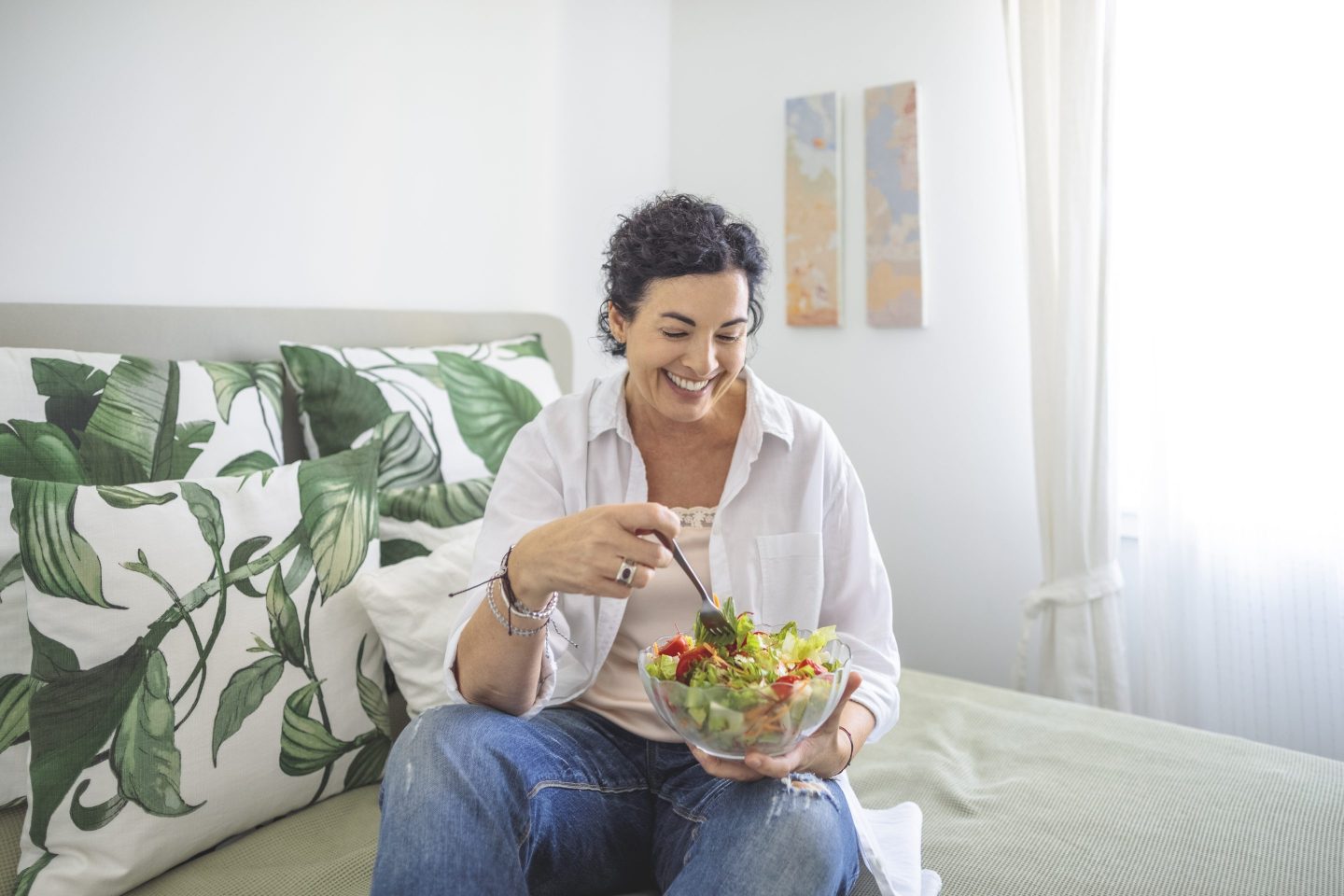 Woman eating salad at home