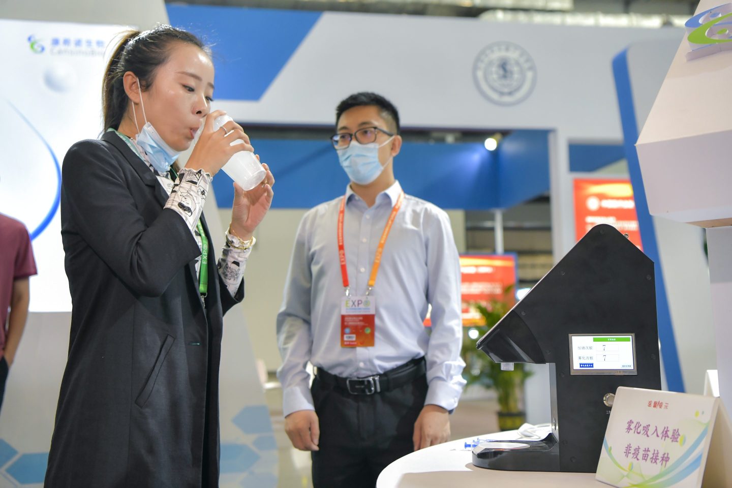 At a health industry expo in 2021 in Hainan, China, a visitor tries inhaling atomized water to demonstrate how CanSino’s inhaled COVID-19 vaccine works. 