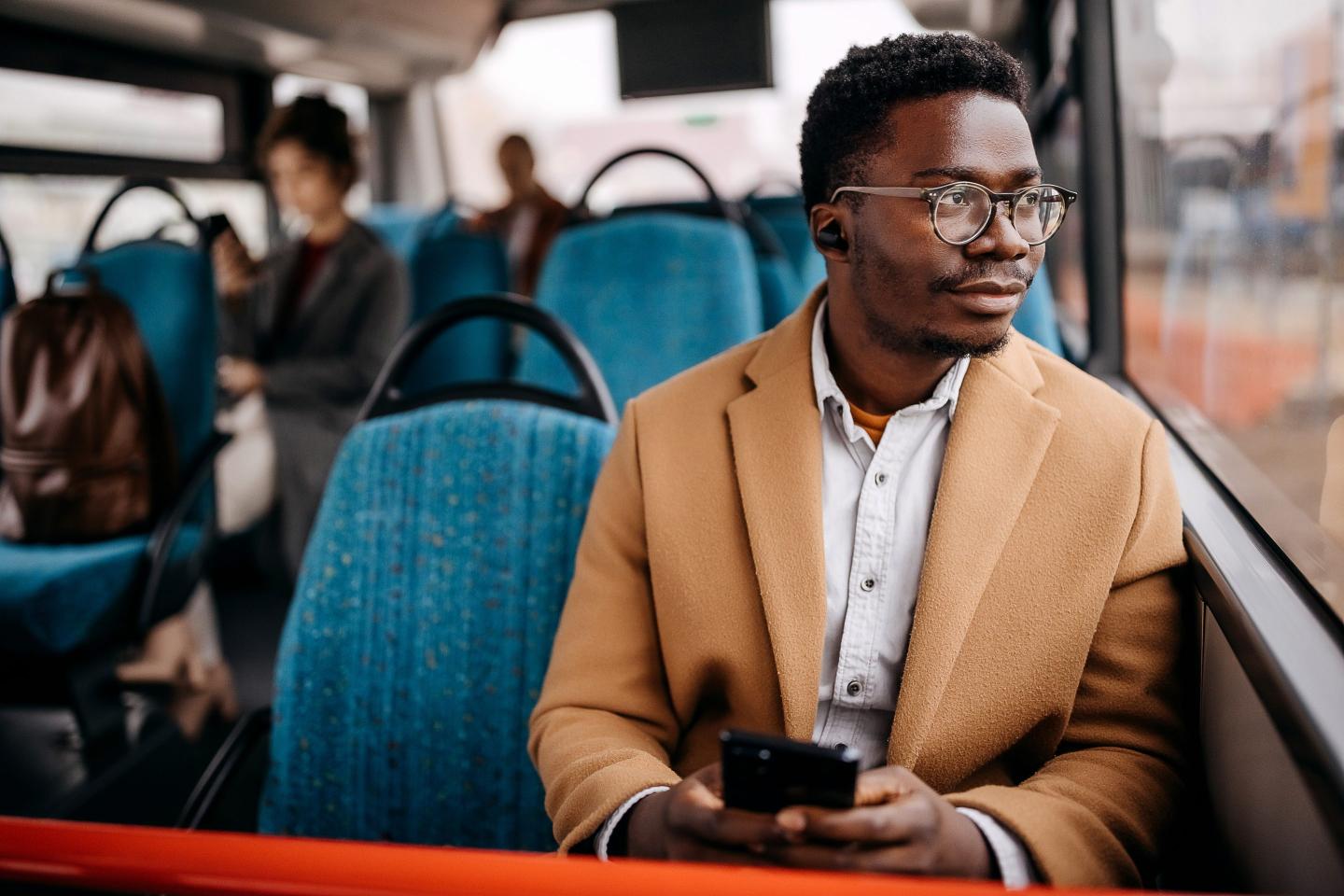 Young handsome businessman in public bus