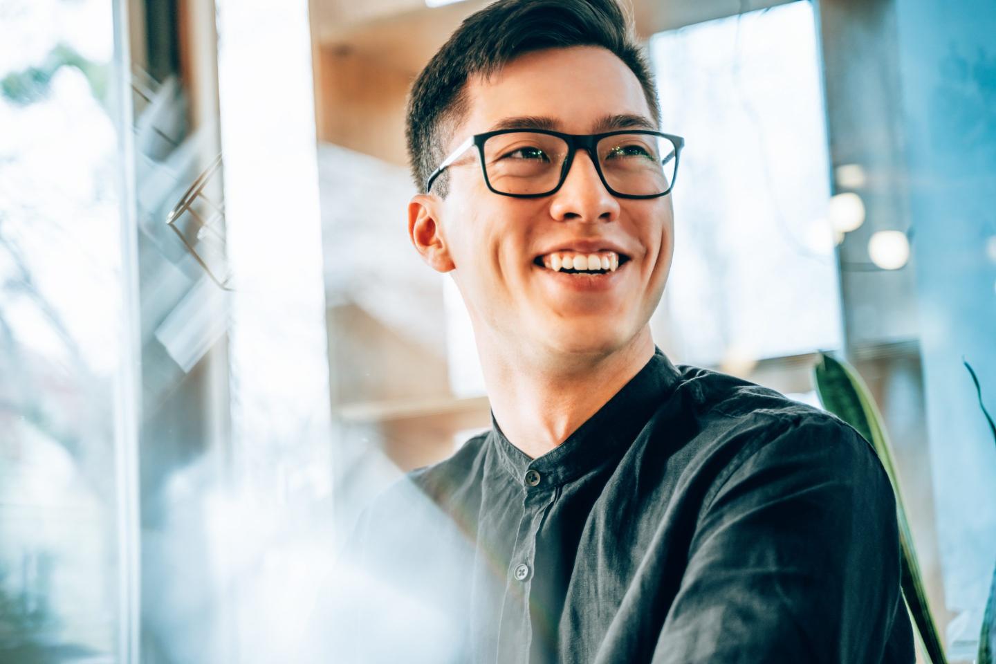 Portrait of a young handsome Asian entrepreneur, smiling and looking forward to the future innovations