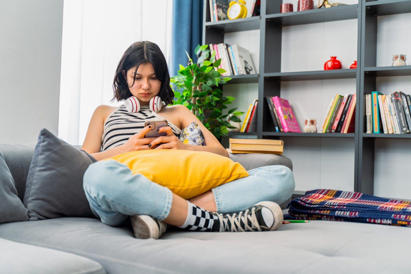 teen girl checking social media holding smartphone at home