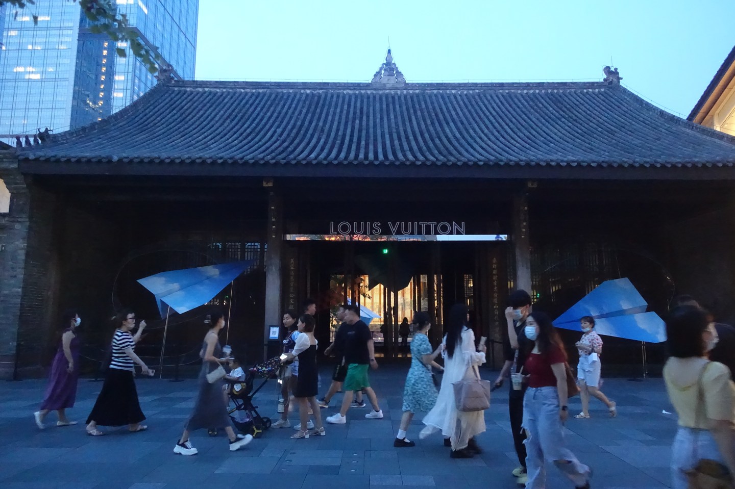 People walk in front of the Louis Vuitton store in Chengdu, China, on Aug. 17, 2022.