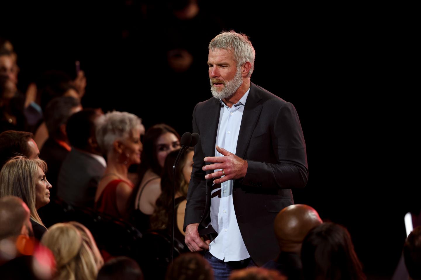 Former NFL star Brett Favre stands on stage to present at award show