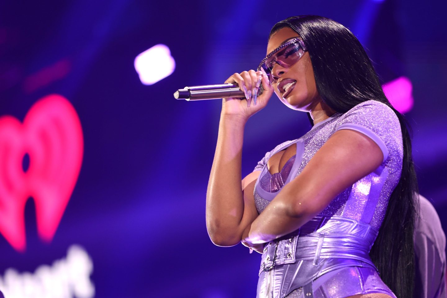 Megan Thee Stallion performs onstage in a purple bodysuit.