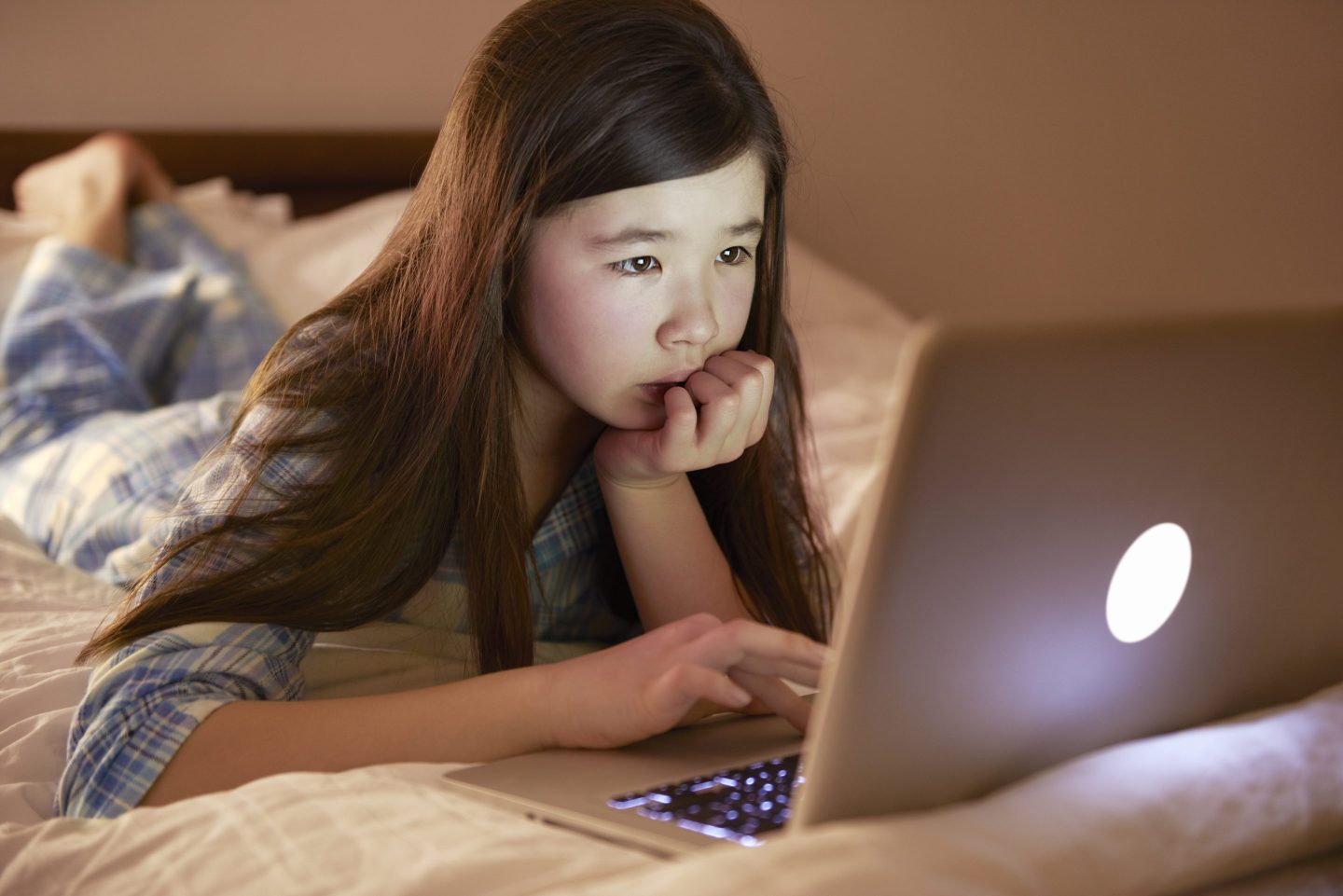 child looking closely at a laptop computer