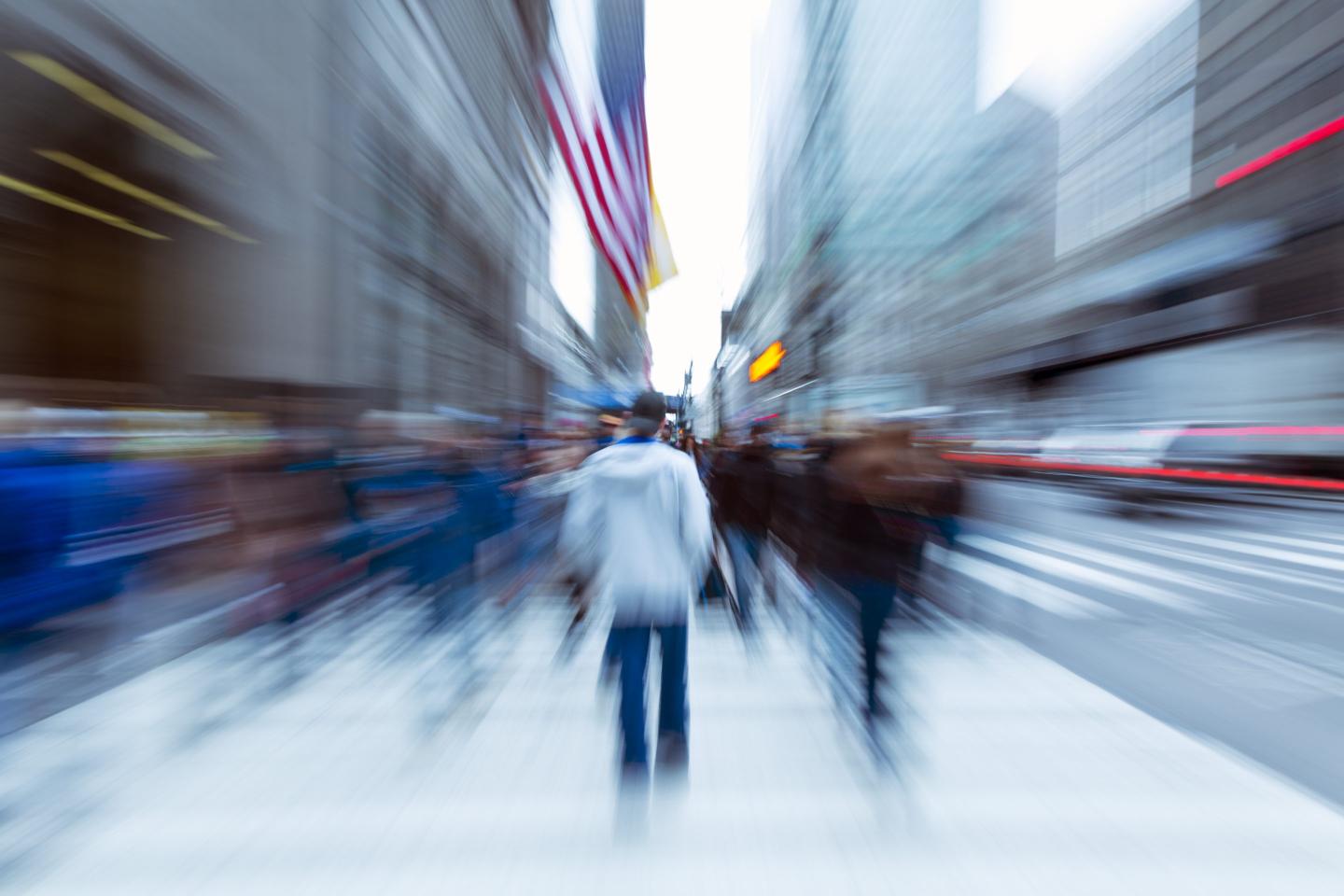 Blurred image of New York City residents walking on sidewalk