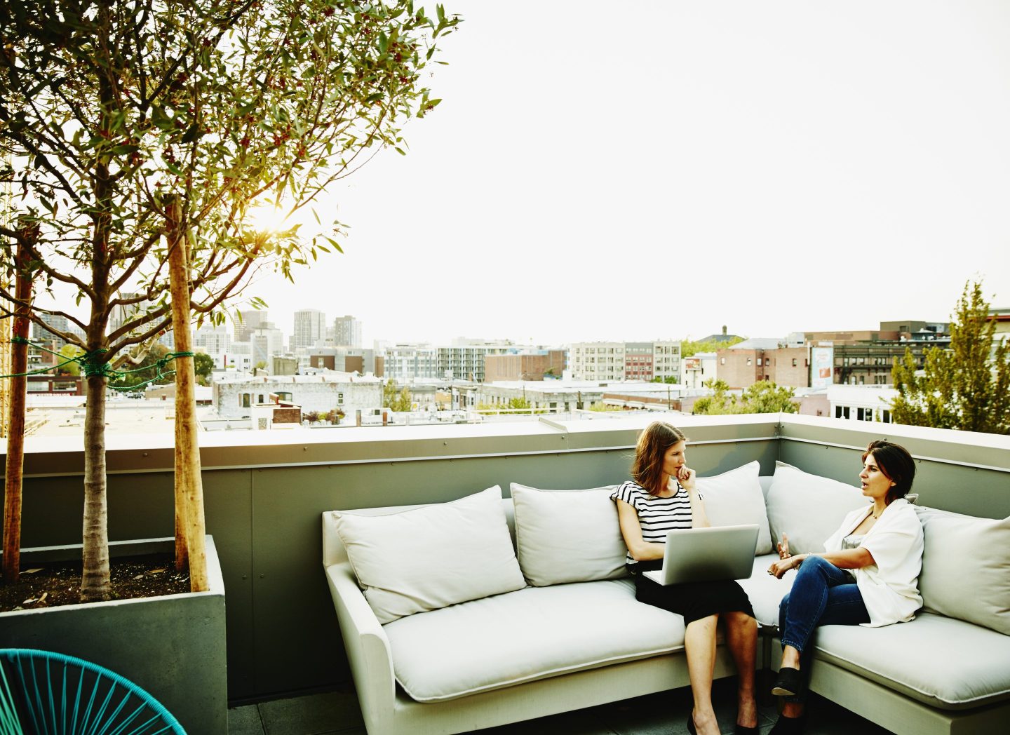 two women sitting outside talking