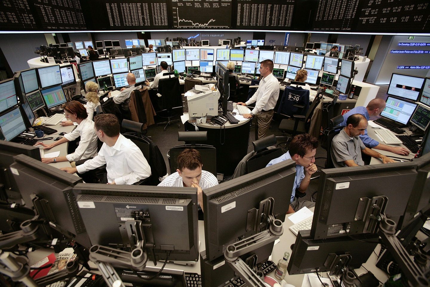 Stock traders staring at computers on the German stock exchange.