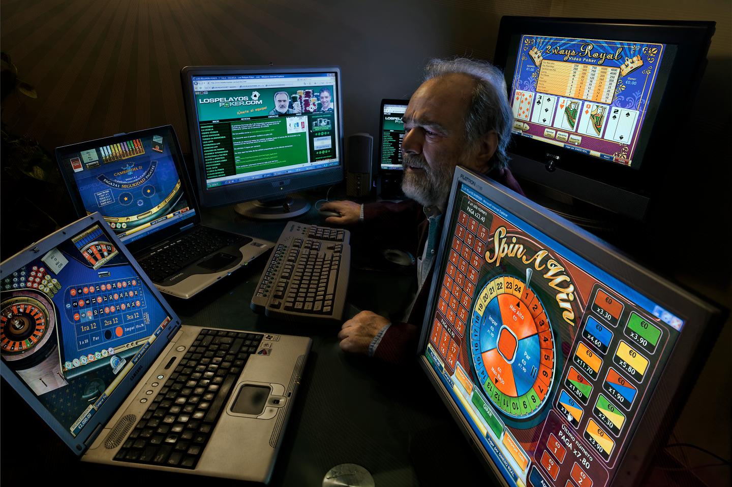 A man surrounded by computers with gambling programs