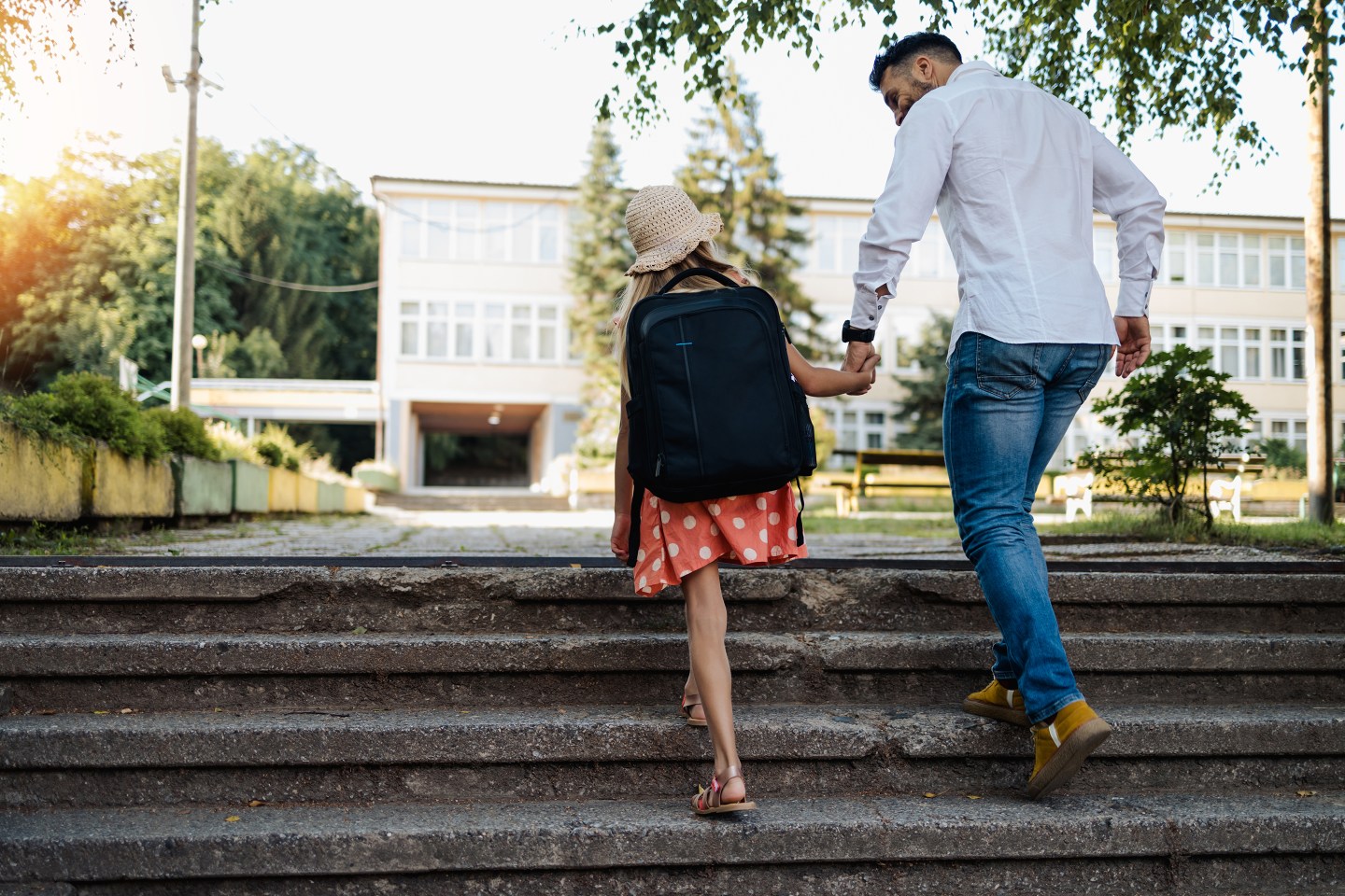 Young father dropping off daughter at school before going to work.